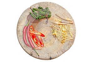 Top view picture of chilli, gingerroot, and pepper on the wooden plate photo