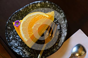 Top View of a piece of orange cake and sliced orange topping with spoon. Cake with orange mousse with copy space