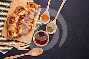 Top view piece of pizza on wooden plate and black stone table
