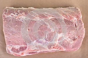 Top view of a piece of raw pork on baking paper.