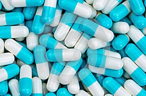 Top view pile of blue and white antibiotic capsule pills texture. Pharmaceutical production. Global healthcare. Antibiotics drug