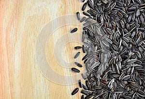 Top view pile of brown sunflower seeds on wooden texture background, copy space