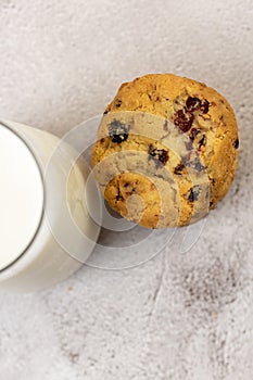 Top view of a pile of chocolate chip cookie beside a glass of milk on a table