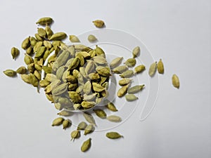 Top view of a pile of green cardamom or cardamon Indian spices on white background.