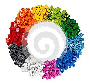 Top view of pile of many various colorful rainbow colored stackable plastic toy bricks in circle shape with copy space isolated