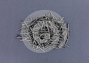 Group of ring shank underlayment nails on a dark paper background photo