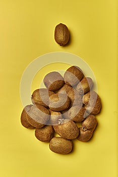 Top view of a pile of ripe kiwis isolated on a yellow background