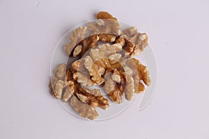 Top view of a pile of shelled walnuts on a white surface