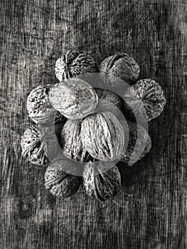 Top view on pile of walnuts lying on a scratched wooden cut