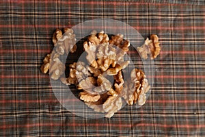 Top view of a pile of walnuts on a plaid fabric