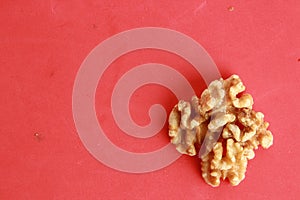 Top view of a pile of walnuts under the lights on a pink background