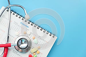 Top view of pills and stethoscope on calendar ,