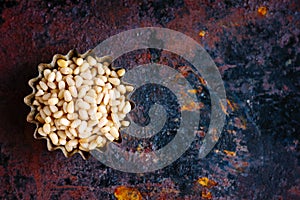 Top view of pine nuts over the rusty background.