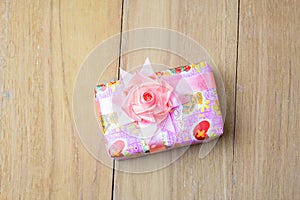 Top view pink gift box on wooden board