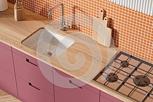 Top view of home kitchen interior with wooden counter and sink with stove