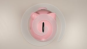 TOP VIEW: Pink pig money box on a white table