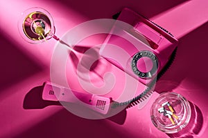 Top view of pink telephone, cocktail and astray with cigarette butts photo