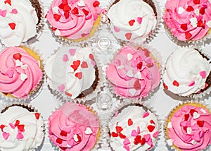 Top view of pink and white Valentine cupcakes decorated with heart sprinkles