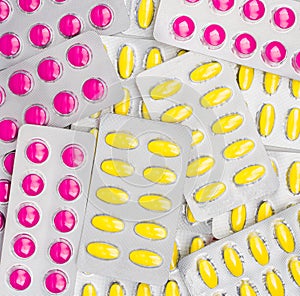 Top view of pink and yellow tablets pill in blister packs. NSAIDs can irritated stomach cause gastric ulcer.
