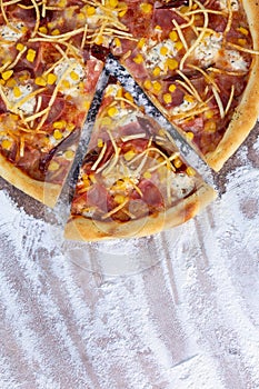 top view pizza with ham and corn on the background of flour.