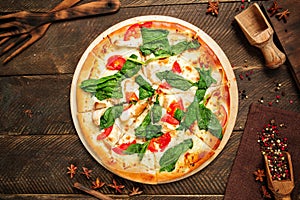 Top view on pizza napoli with spinach and tomatoes