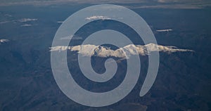 top view through the plane of mountain ranges with little snow of switzerland, concept of climate