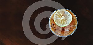 Top view of plastic glass of iced lemon tea with sliced lime or lemon