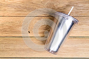 Top view  plastic tumbler cup with straw or tube on wooden background