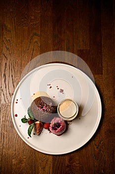 top view on plate with chocolate cake with ice and jar of cream