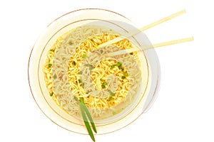 Top view of plate of fastfood soup with green onion, chopsticks and raw ramen instant noodle uncooked