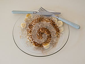 Top view of plate with sliced bananas with oatmeal, sugar and cinnamon.