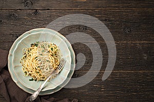 Top view plate of spaghetti AGLIO E OLIO on wooden background with copy space