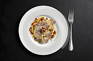 Top view of Plate with spaghetti carbonara on black stone