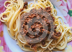 Top view on a plate with spaghetti topped with fried force meat