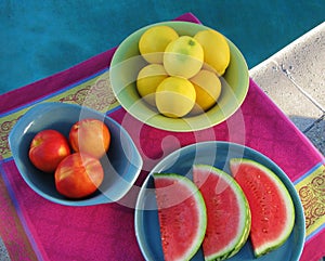 Top view of poolside party table with fresh, juicy fruit served on retro ceramics