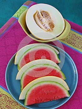 Top view of poolside party table with fresh, juicy melon served on retro ceramics