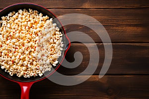 Top view popcorn on frying pan, wood table, copy space, snack concept or recipe background