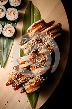 Top view of a portion of philadelphia rolls with eel with sauce and sesame seeds, maki with shrimp filling are next to