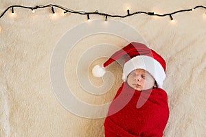 Top View Portrait First Days Life Newborn Cute Funny Sleeping Baby In Santa Hat Wrapped In Red Diaper At White Garland