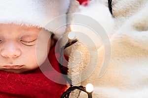 Top View Portrait First Days Of Life Newborn Cute Funny Sleeping Child Baby In Santa Hat Wrapped In Red Diaper At White