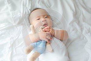 Top view Portrait of a newborn Asian cute baby boy wore blue Infant bodysuit on the bed , Charming Fat baby 5 month old lies in