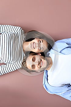 Top view portrait of smiling young couple lying relaxing on warm floor at home, happy family relaxing at home
