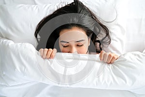 Top view of portrait young of beautiful Asian woman sleep on the white bed under blanket in the modern bedroom