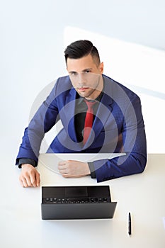 Top view portrait of young confident businessman sitting at his desk