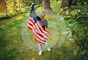 Top view portrait of young handsome man holding flag of America