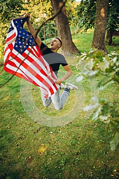 Top view portrait of young handsome man holding flag of America