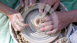 Top view on Potter`s Hands Work with Clay on a Potter`s Wheel. Slow motion