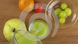 Top view pouring fresh green guava juice into transparent glass.