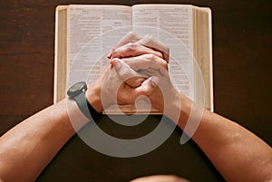Top view, praying and man with bible, hands and spiritual with religion and faith for guidance and scripture. Closeup