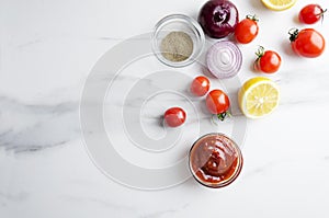 Top view of preparation of tomato sauce,ketchup with different ingredients on white marble table